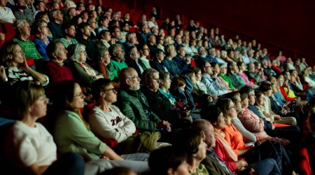 A crowd is watching the documentary in the cultural centre.